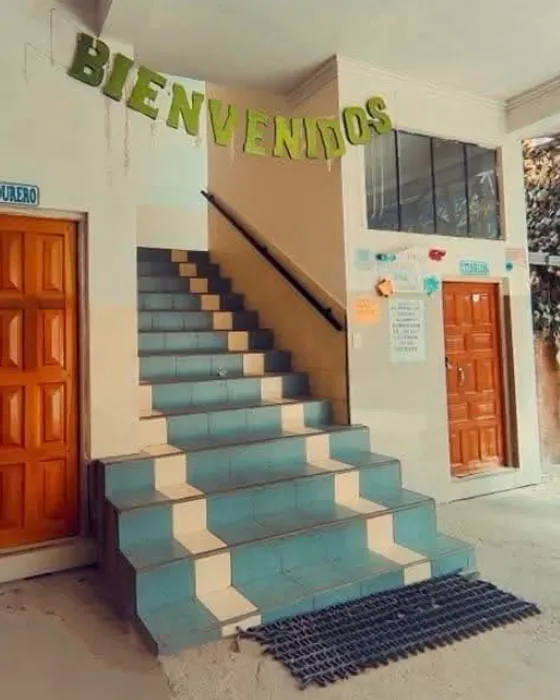 Entrada de la iglesia IEMAO en Villa Ingenio: la escalera de gradas celestes y el letrero de «Bienvenidos» sobre la puerta